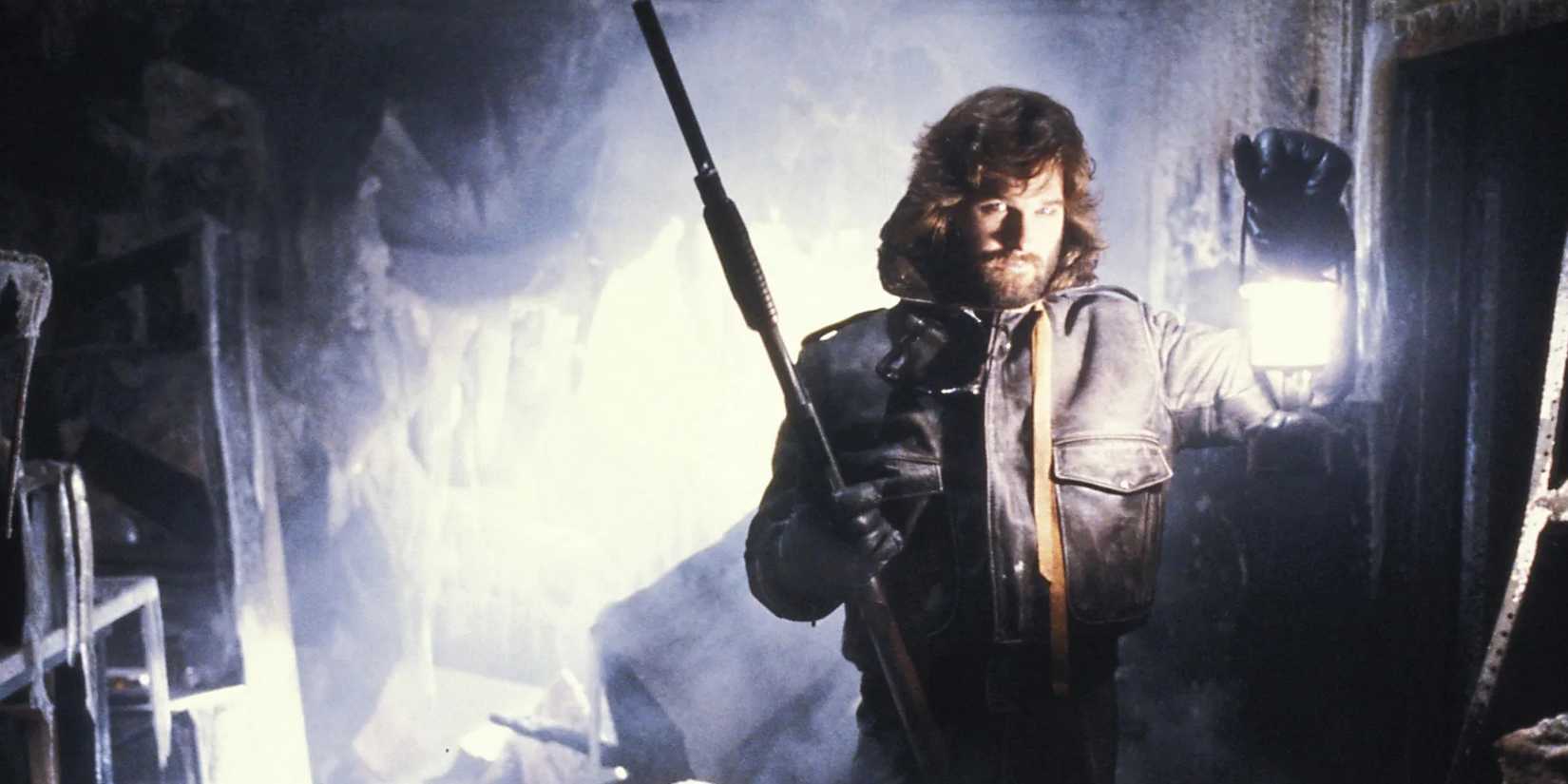Macready (Kurt Russell) holding a lantern and a gun in 'The Thing' (1982).