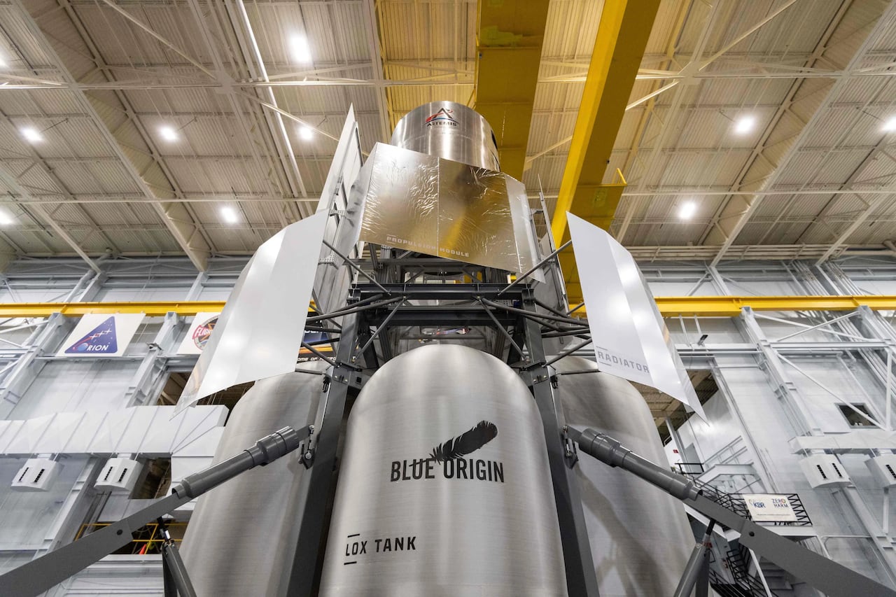 A silver spacecraft sits inside a building.