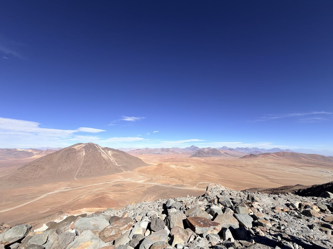 A view of a desert and mountains under a blue sky.