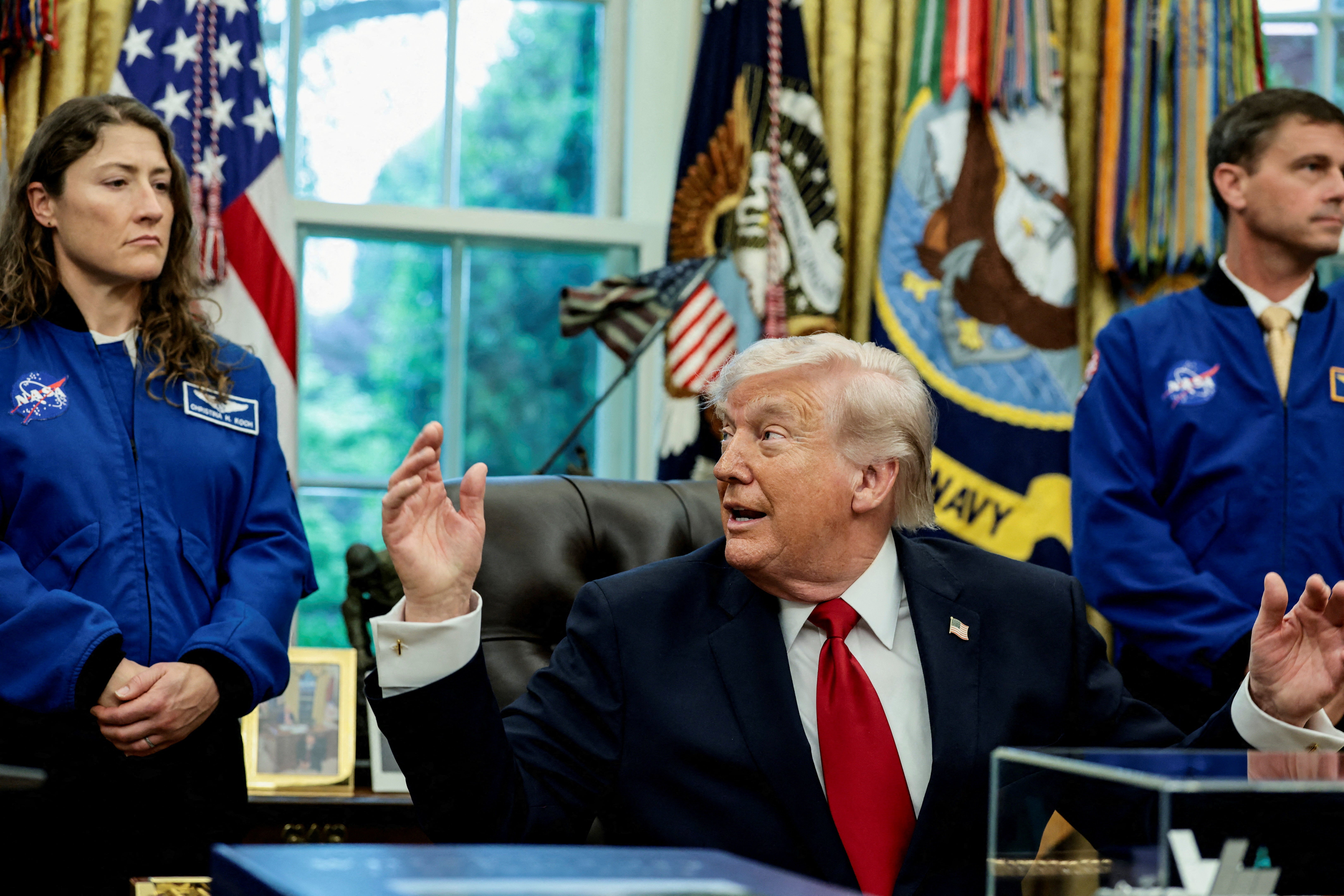 Artemis II astronauts, NASA Commander Reid Wiseman and NASA Mission Specialist Christina Koch, flank U.S. President Donald Trump as he speaks during an event in the Oval Office at the White House in Washington, D.C., U.S., April 29, 2026. REUTERS/Evelyn Hockstein/File Photo
