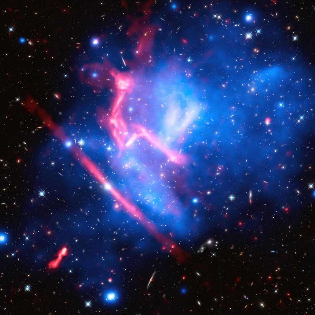 Colliding galaxy clusters MACS J0717+3745, more than 5 billion light-years from Earth. Background is Hubble Space Telescope image; blue is X-ray image from the Chandra Telescope, and red is VLA radio image.