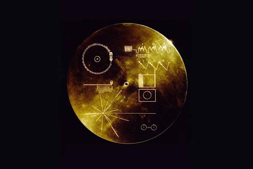 When the twin Voyager probes launched in 1977, each carried a copy of a gold-plated phonograph record featuring audio and video recordings from Earth. Their protective covers, pictured here, featured schematic explanations of how to play and decode the data (top and center); a map of the location of our Sun relative to 14 known pulsars (lower left); and a diagram of the spin-flip transition of the hydrogen atom which produces emission at 1420.4 MHz. The time period between passing wave crests at this frequency provided the reference unit for time periods in the other diagrams, which were expressed in binary. Credit: NASA/JPL
