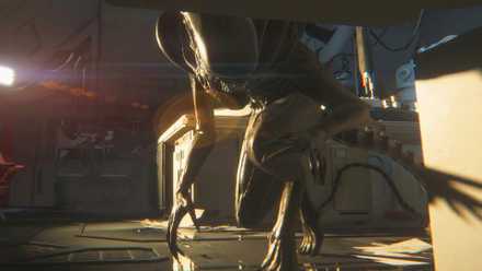 Alien: Isolation's Xenomorph peeks under a desk where the player is hiding.