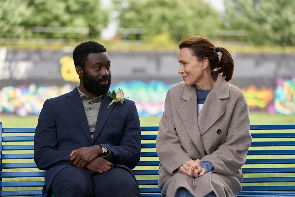 two individuals sitting on a bench in an outdoor setting