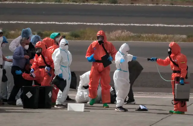 Passengers are sprayed with disinfectant