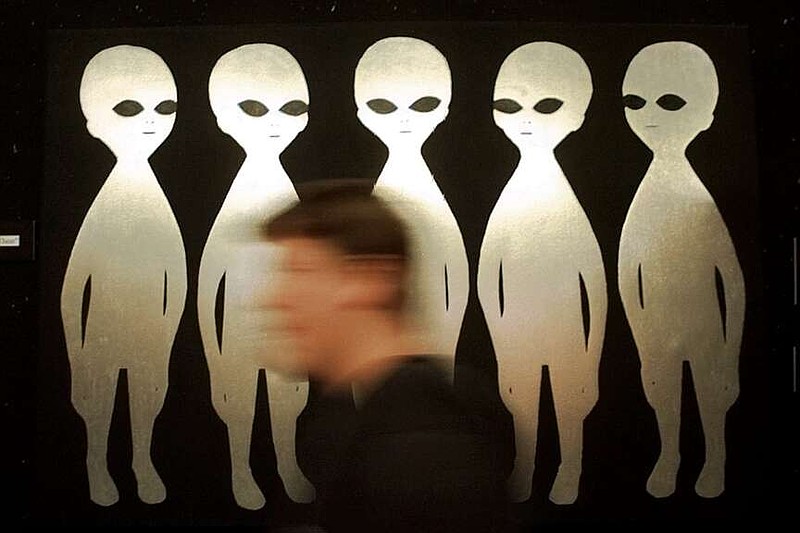 FILE - A patron passes a painting inside the International UFO Museum and Research Center in Roswell, N.M., on June 10, 1997. (AP Photo/Eric Draper, File)