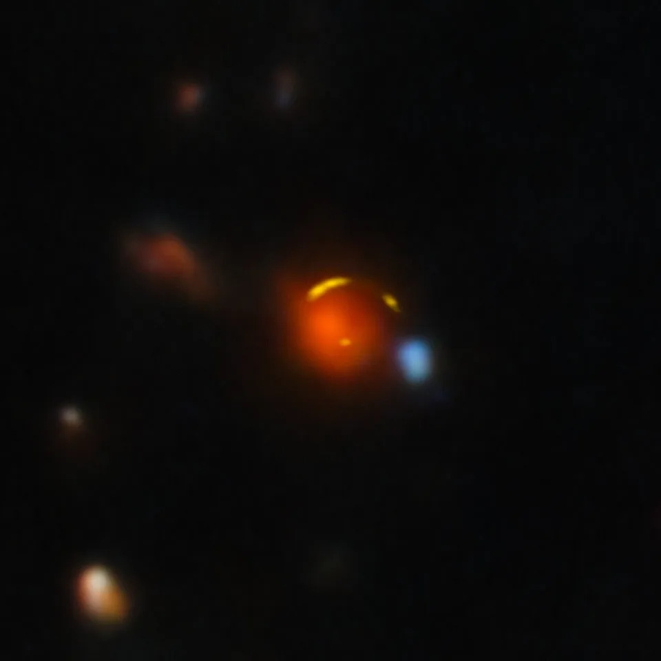 This image shows the gravitationally lensed galaxy nicknamed “Shadow Blaster,” which astronomers have identified as the likely source of the high-energy neutrino event IC 210922A, detected by the IceCube Neutrino Observatory in 2021. (CREDIT: IceCube Neutrino Observatory)