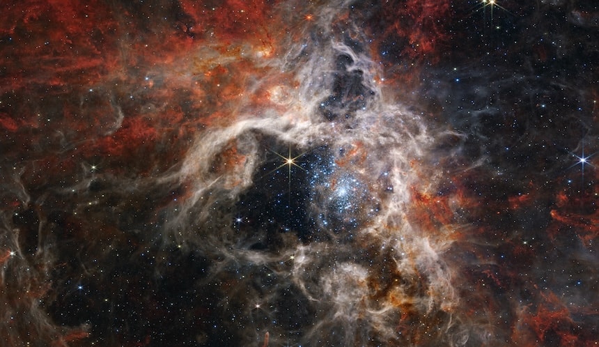 A massive, multicoloured nebula in space looks like huge puffy clouds of cotton candy.