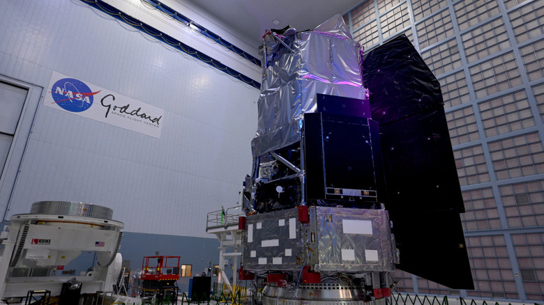 A spacecraft with the NASA Goddard logo in the background.