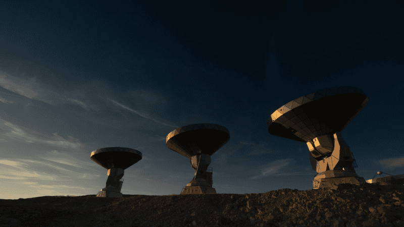 Top scientists warn never to reply to alien contact A row of radio telescope dishes silhouetted against a twilight sky, representing SETI research facilities