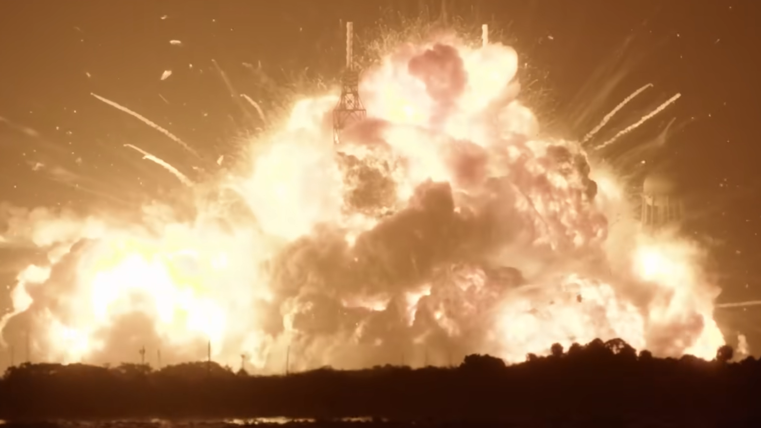 A fireball erupts from a launchpad.
