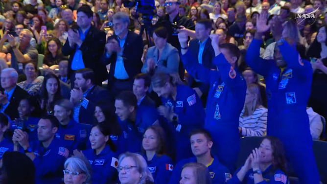NASA astronauts applaud during the announcement of the Artemis III crew.
